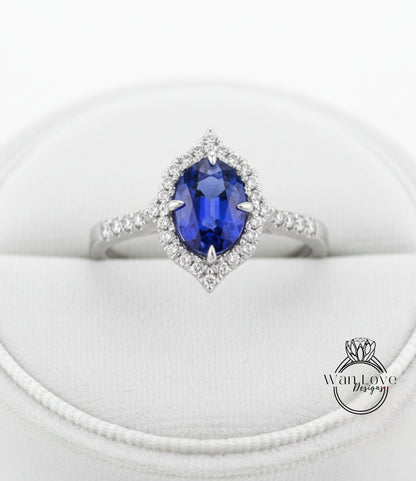 A close-up view of a diamond engagement ring with a large oval-shaped blue gemstone surrounded by a halo of smaller diamonds.