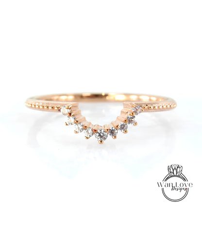 A rose gold ring with a diamond-encrusted band and a row of small diamonds set in the center.