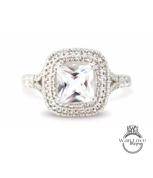 A diamond ring with a large central gemstone surrounded by smaller diamonds set in a halo of smaller diamonds.