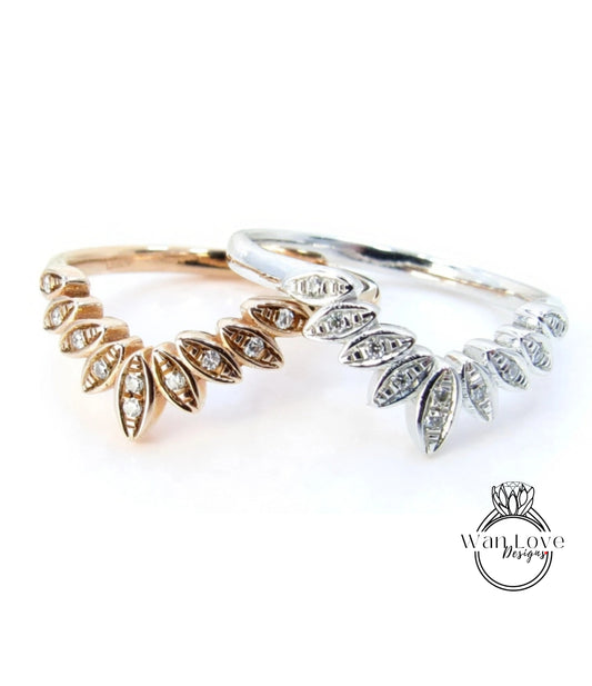 Two rings with diamond-encrusted designs, one in gold and one in silver, are displayed against a white background.
