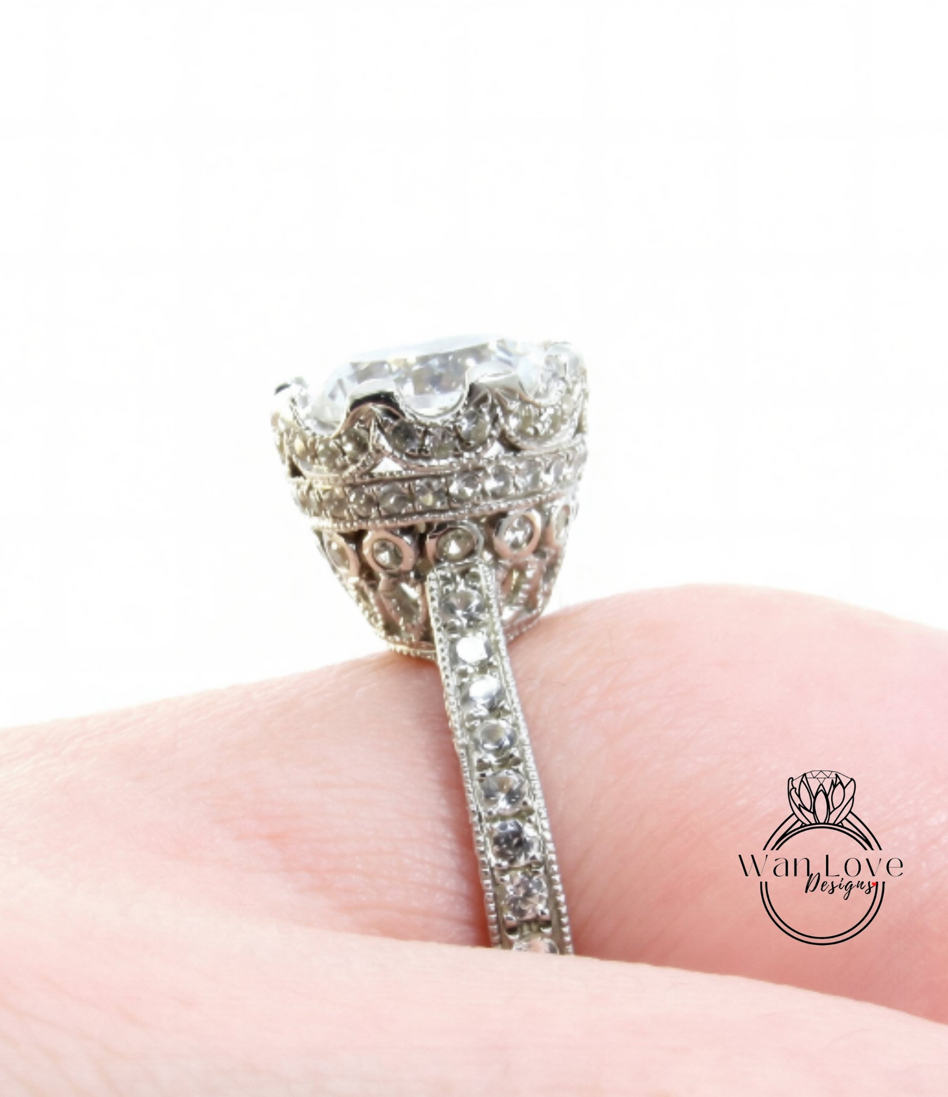 A close-up of a diamond engagement ring on a person's finger, showcasing the intricate details and sparkling gemstones.
