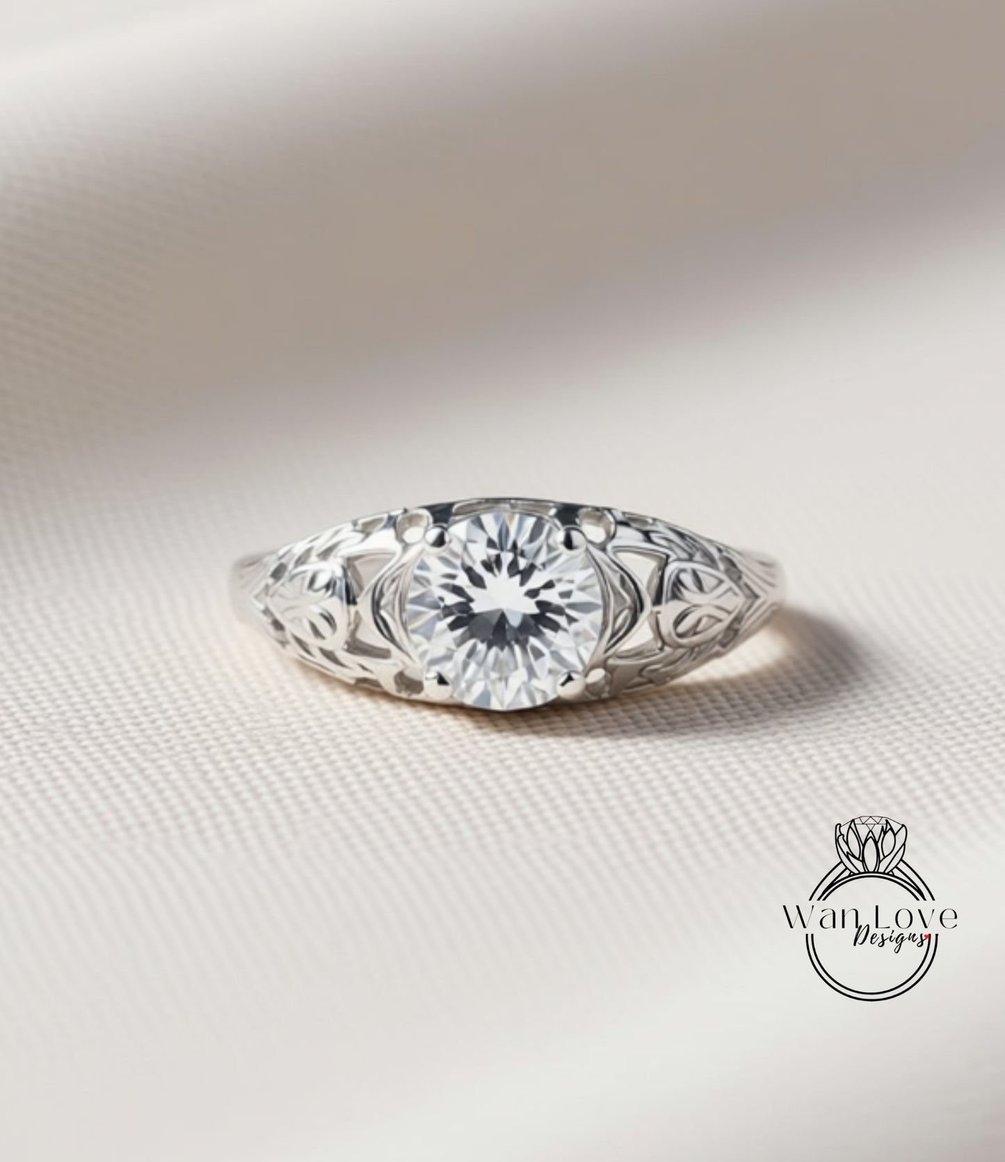 A close-up image of a silver ring with a large, clear gemstone set in the center, surrounded by intricate floral designs.