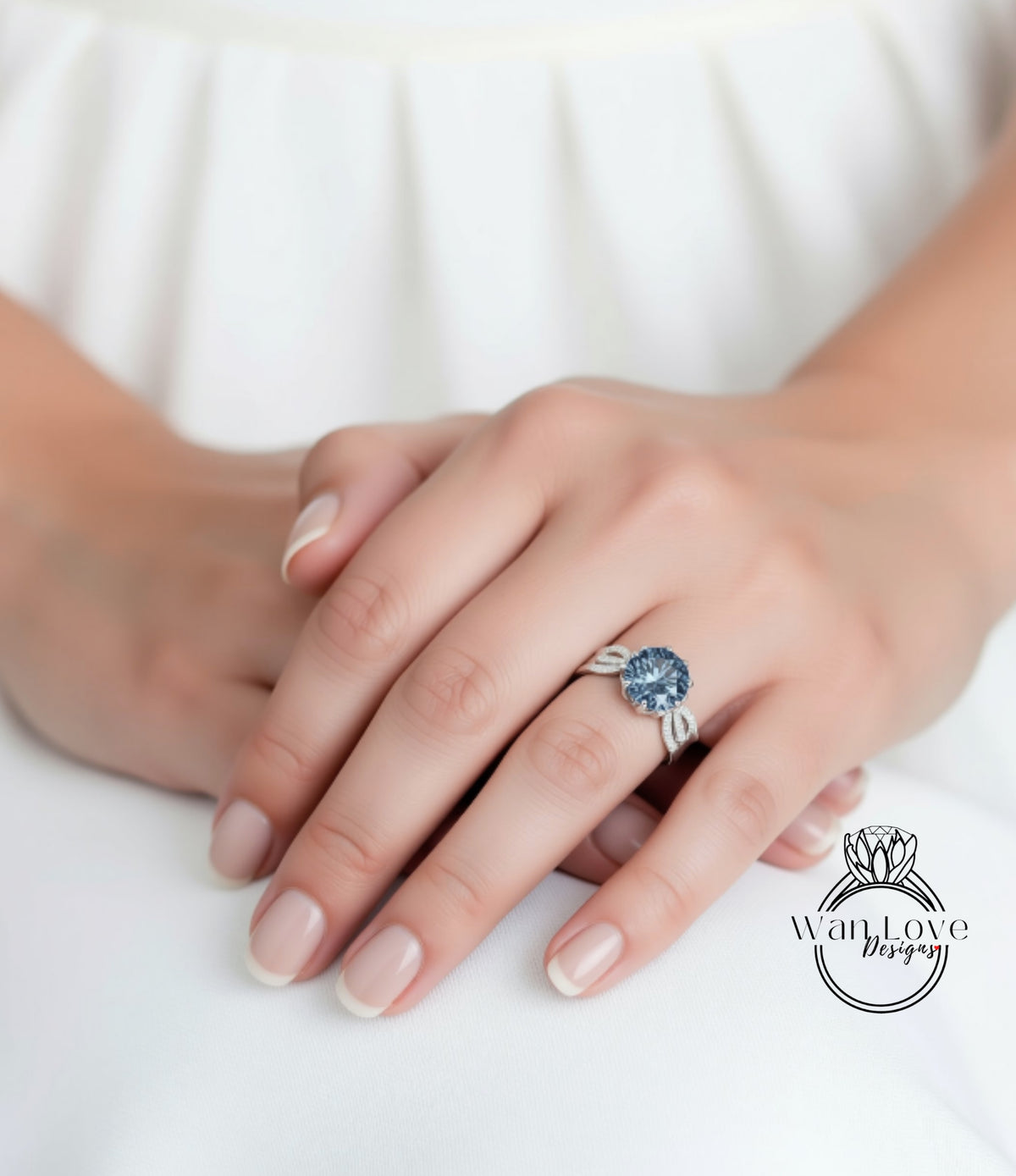 A close-up of a person's hand wearing a ring with a large blue gemstone.