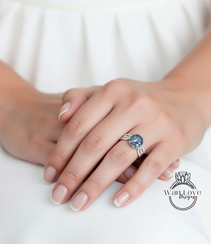A close-up of a person's hand wearing a ring with a large blue gemstone.