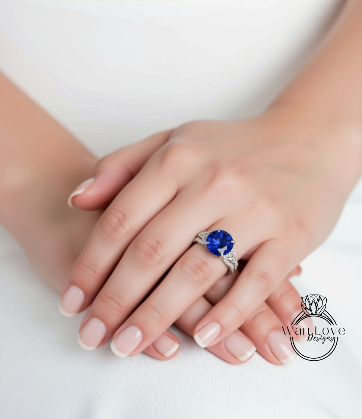 A close-up image of a person's hands wearing a large blue gemstone ring.