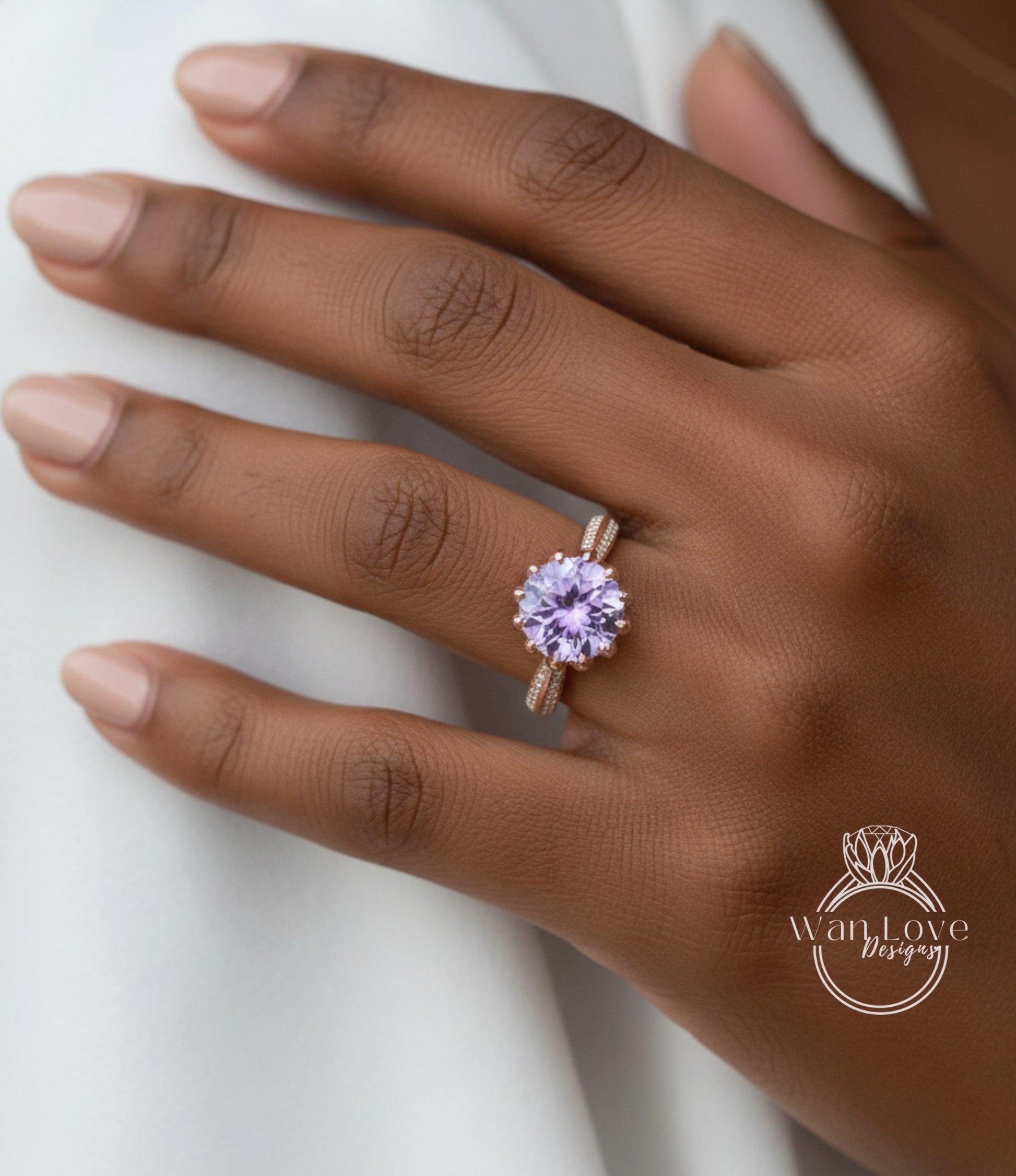 A close-up of a hand wearing a ring with a large purple gemstone.