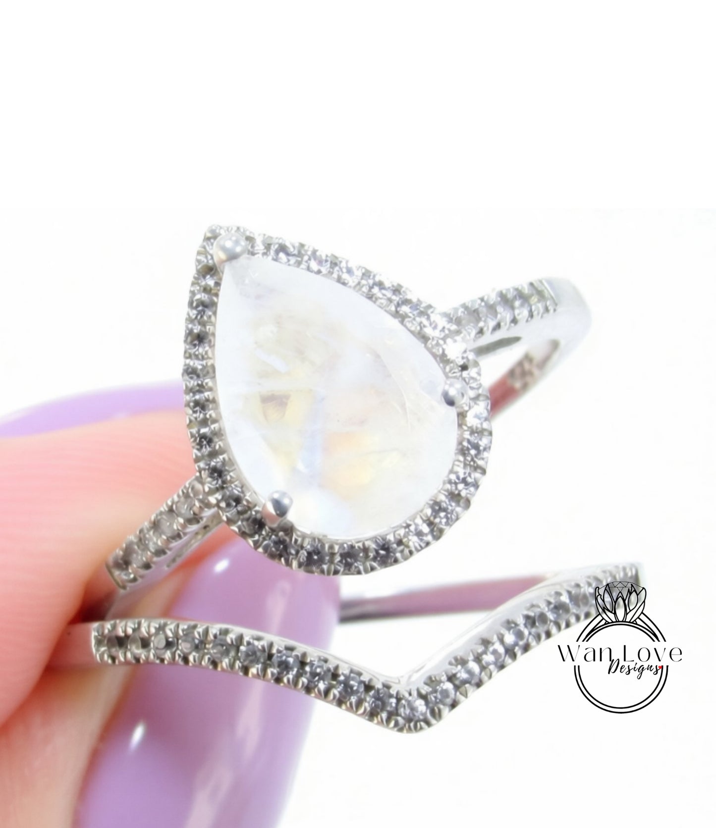 A close-up of a silver ring with a large, clear gemstone, possibly a diamond, set in a halo of smaller diamonds.