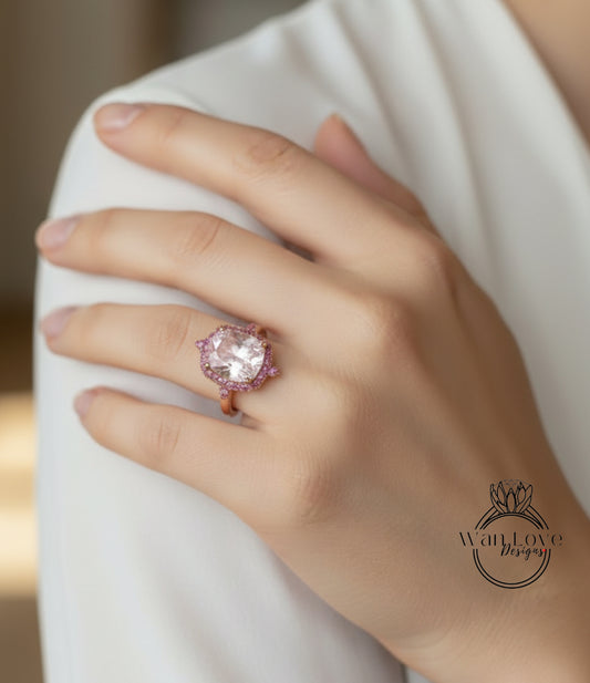 A close-up of a person's hand wearing a large, ornate ring with a pink gemstone.