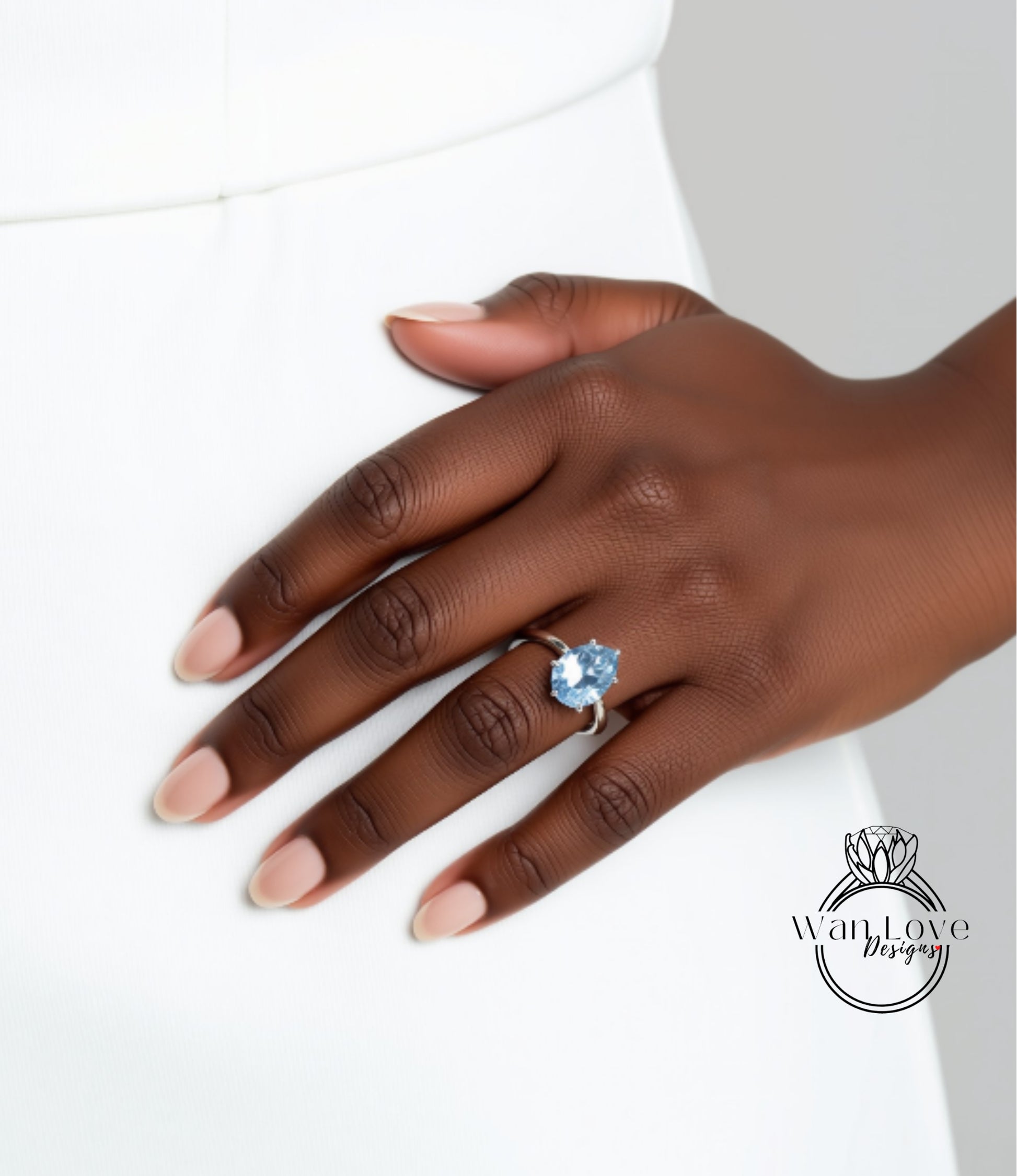 A close-up of a hand wearing a ring with a blue gemstone.