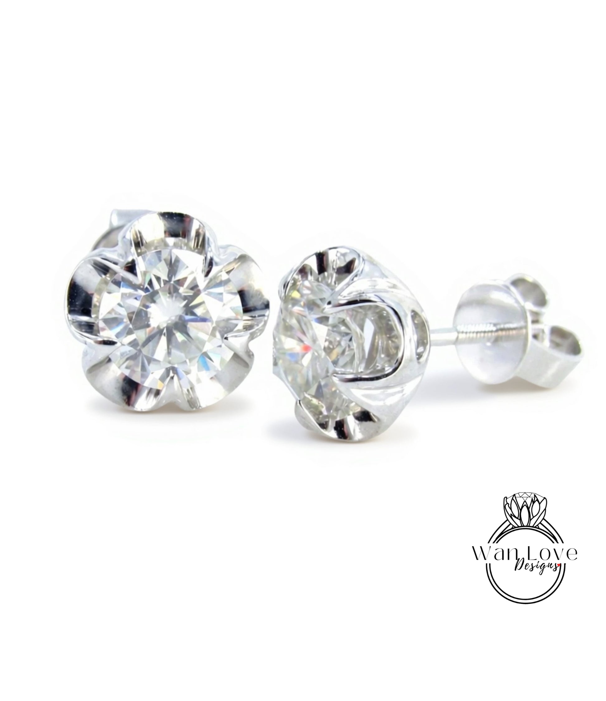 A pair of elegant diamond stud earrings with a large, brilliant-cut diamond set in a silver metal frame.