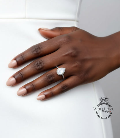 A close-up of a hand wearing a diamond engagement ring.