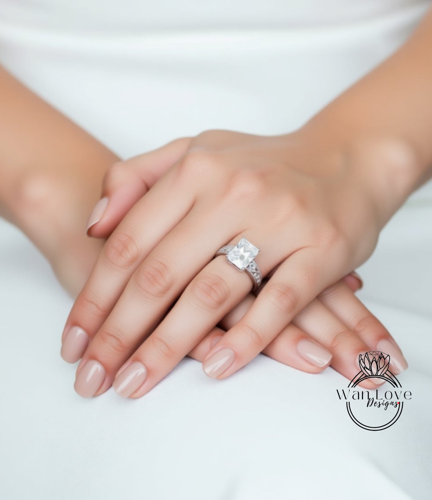 A close-up image of a person's hands wearing a large diamond engagement ring.