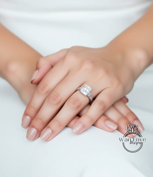 A close-up image of a person's hands wearing a large diamond engagement ring.
