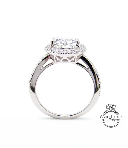 A close-up view of a silver engagement ring with a large central diamond surrounded by smaller diamonds, set in a halo of smaller diamonds.