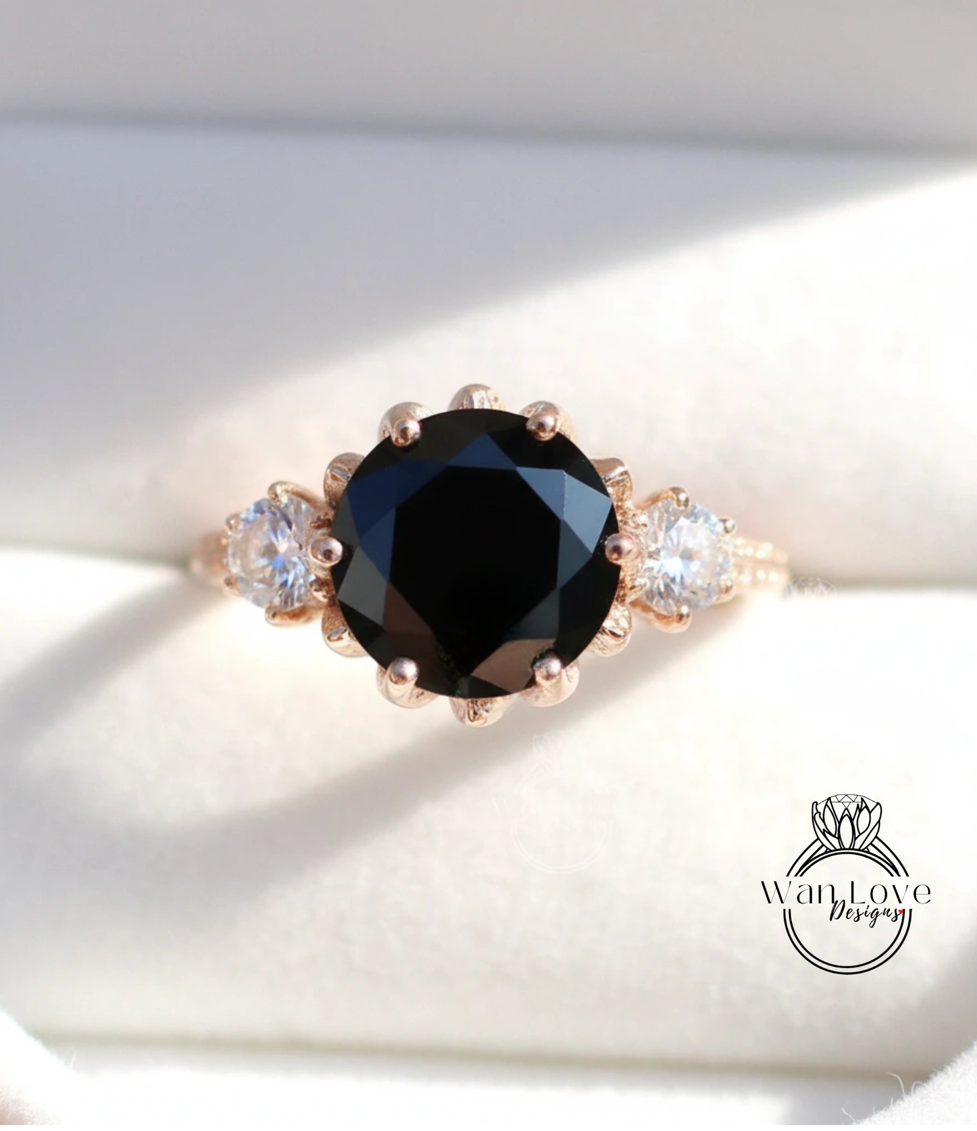 A close-up image of a gold ring with a large black diamond as the centerpiece, surrounded by smaller diamonds.