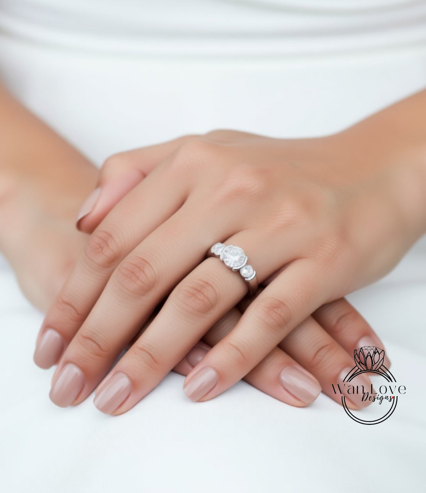 A close-up image of a person's hands wearing a diamond engagement ring.