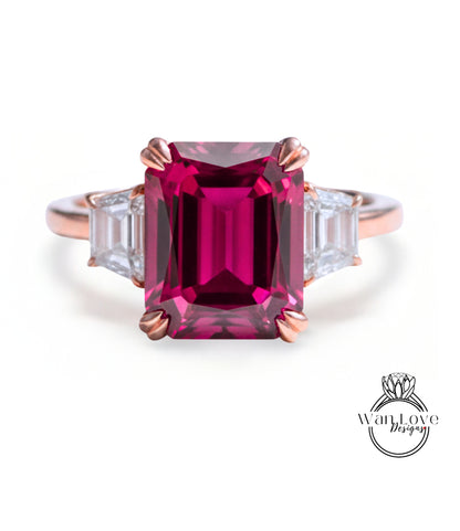 A pink gemstone engagement ring with a large central gemstone surrounded by smaller diamonds on either side.