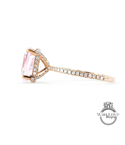 A close-up view of a gold ring with a large pink gemstone, possibly a diamond, set in the center.