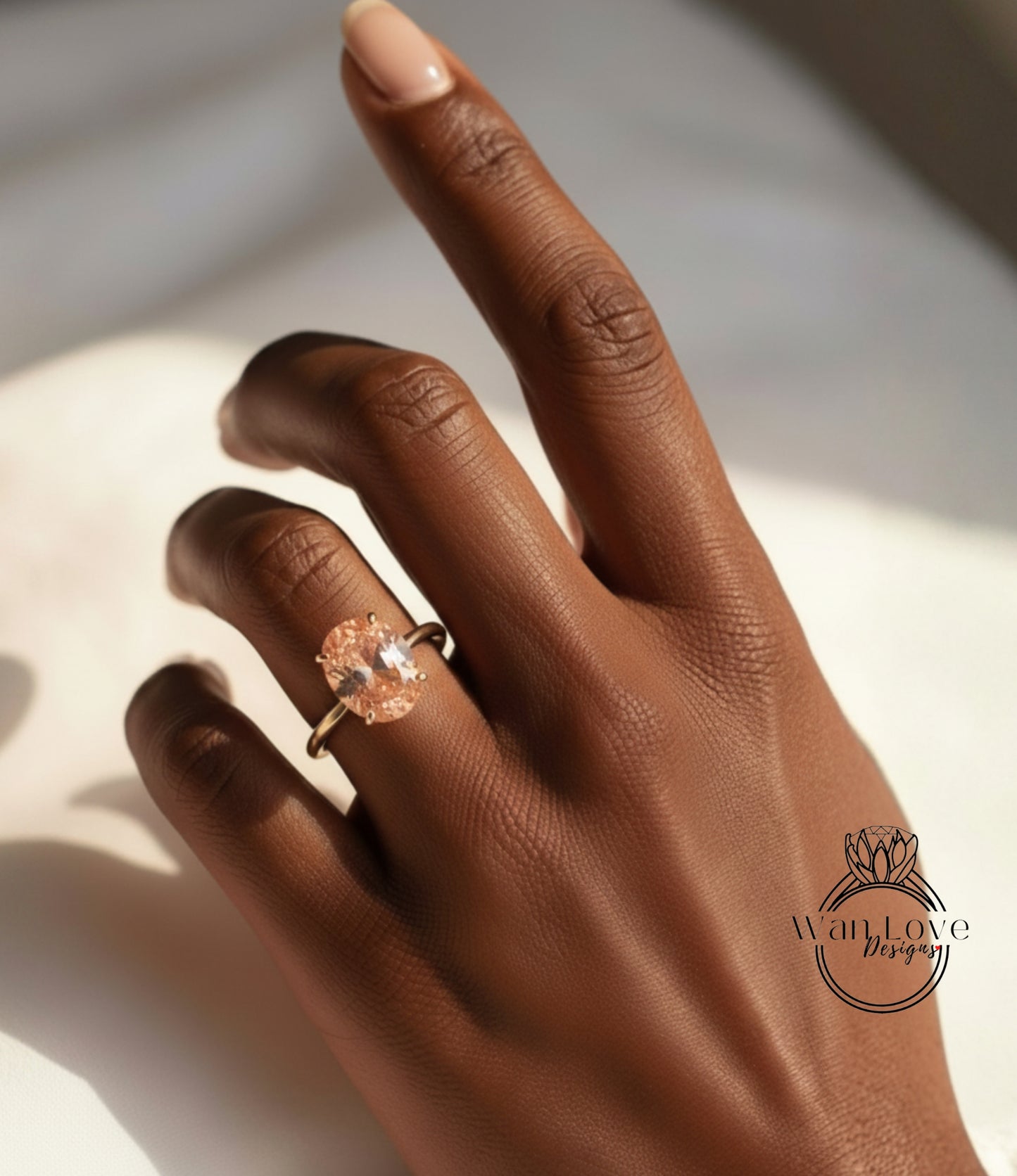 A close-up of a hand wearing a gold ring with a large oval-shaped gemstone.