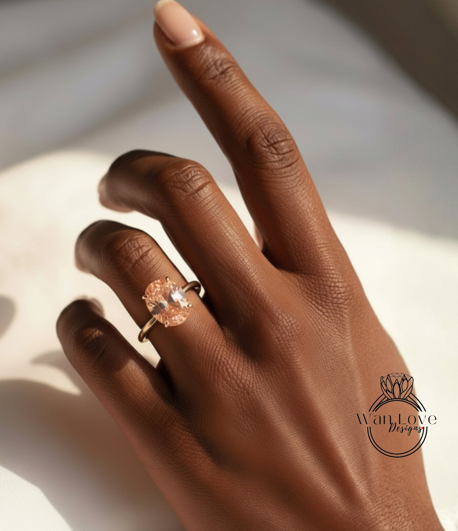 A close-up of a hand wearing a gold ring with a large oval-shaped gemstone.
