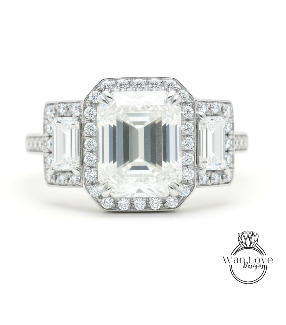 A close-up of a diamond engagement ring with a large central diamond surrounded by smaller diamonds on either side.