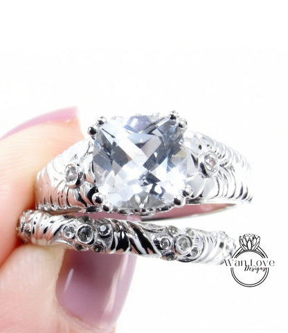 A close-up image of a person's hand holding a silver ring with a large, clear gemstone set in it.