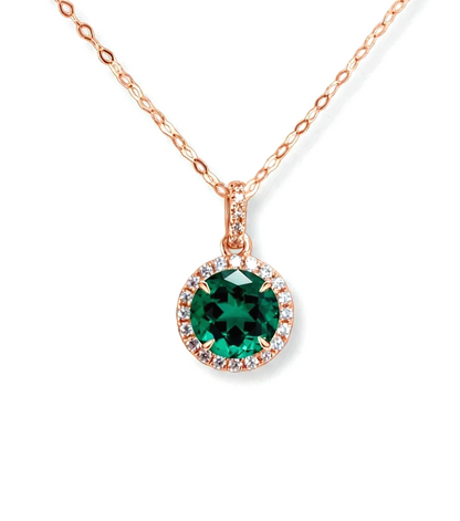 A necklace with a large, green gemstone pendant surrounded by smaller diamonds.