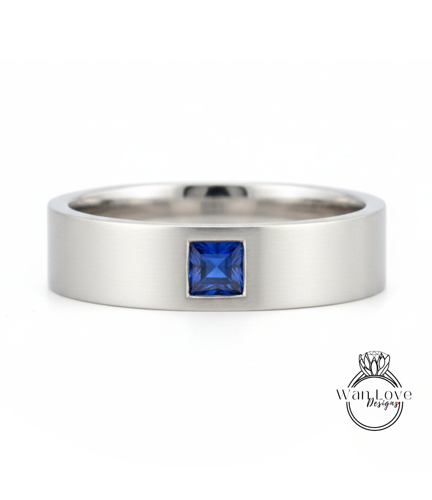 A silver ring with a blue gemstone, likely a sapphire, set in the center.