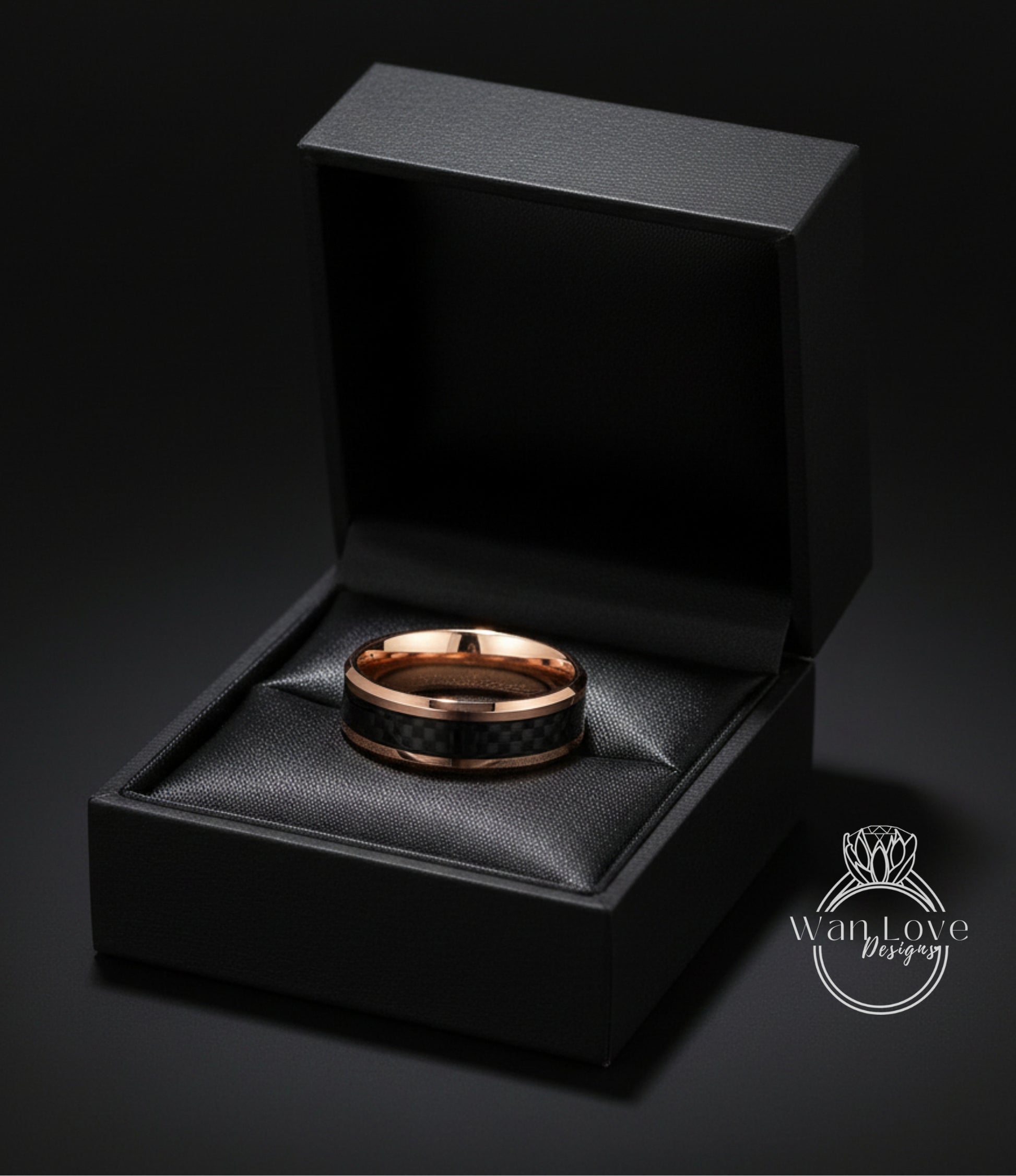 A gold-toned ring is displayed in a black jewelry box against a dark background.