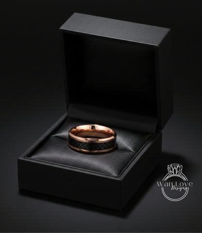A gold-toned ring is displayed in a black jewelry box against a dark background.