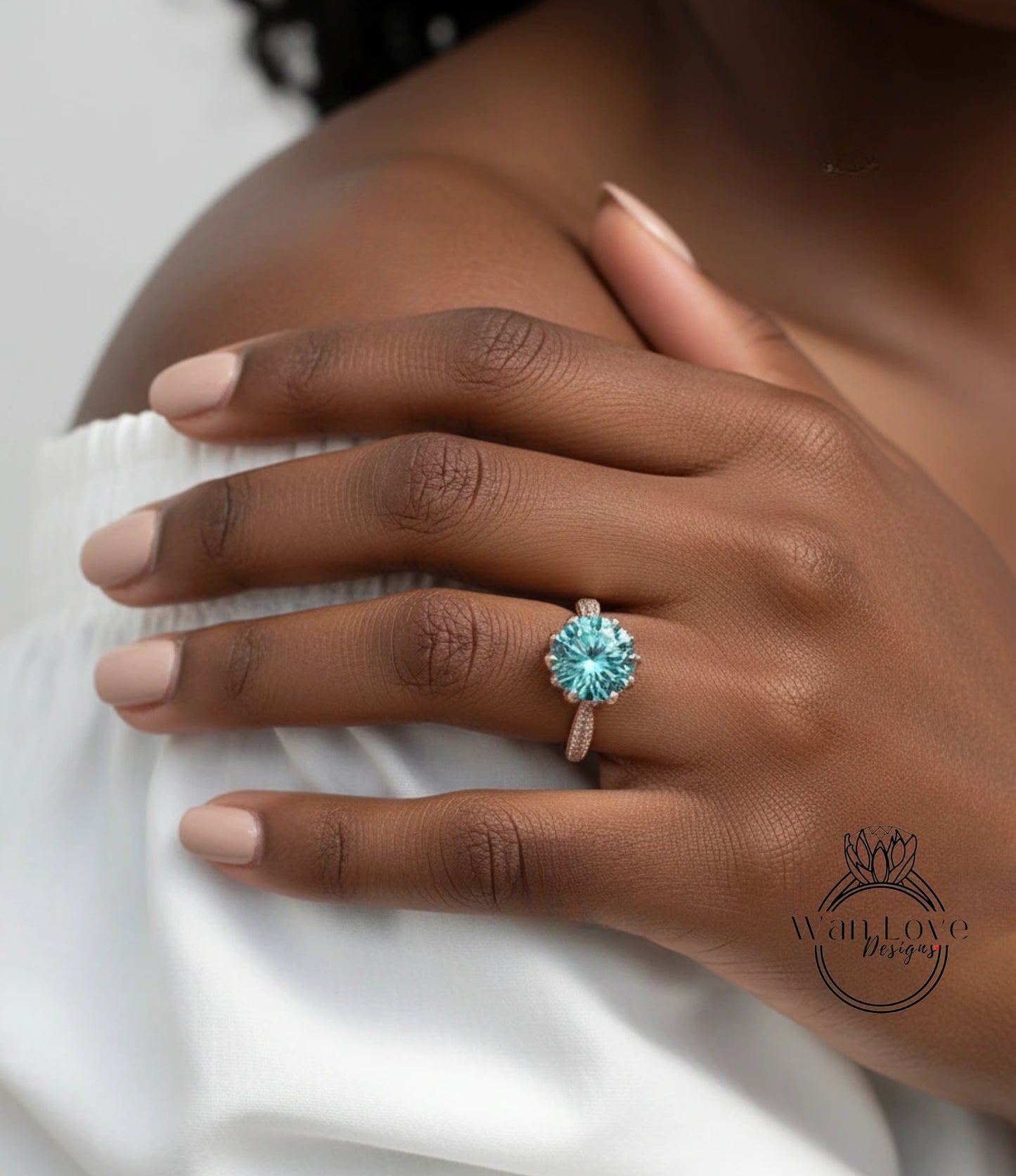A close-up of a person's hand wearing a ring with a large blue gemstone.