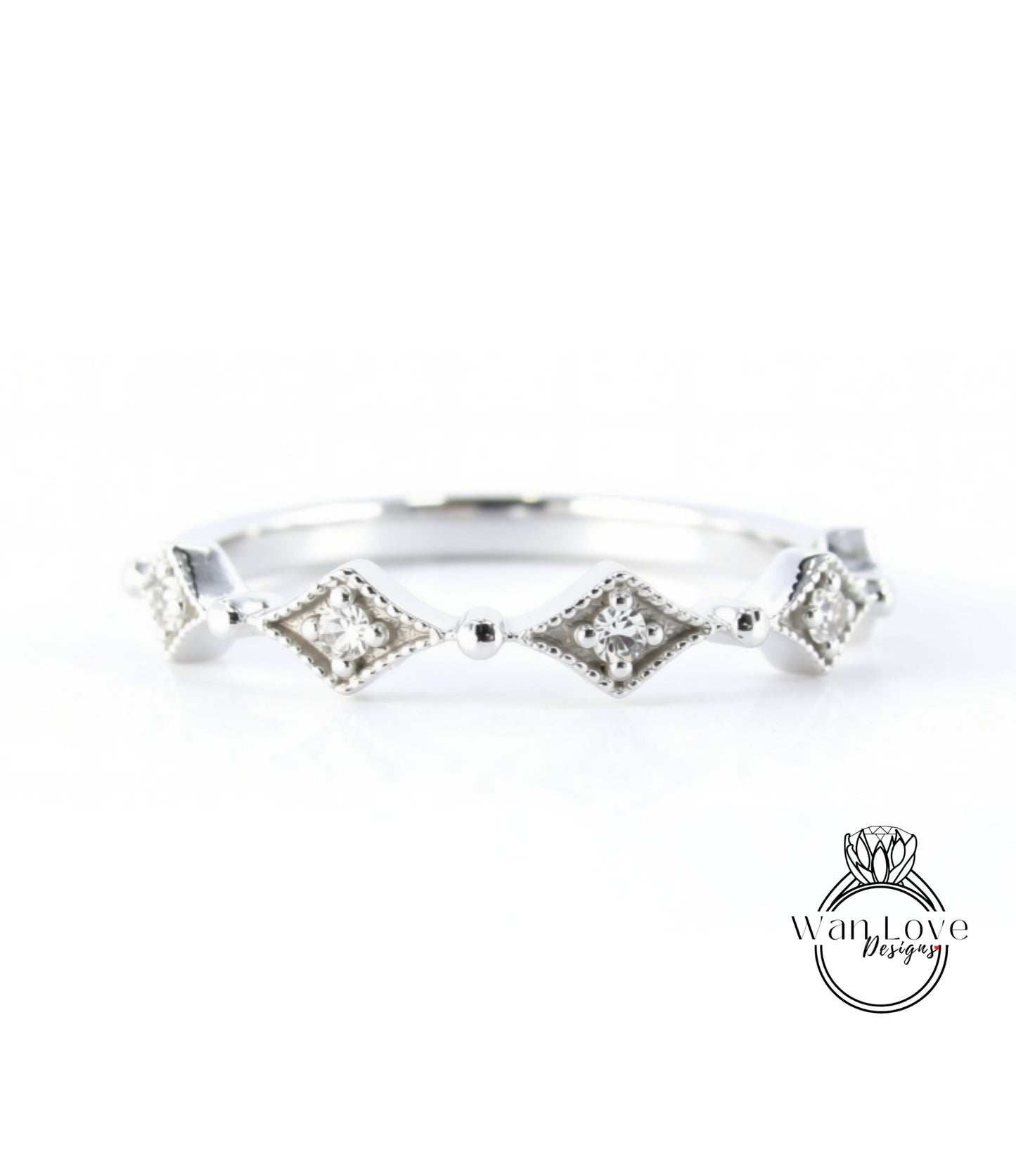 A silver ring with a row of diamond-shaped stones set in a decorative pattern.