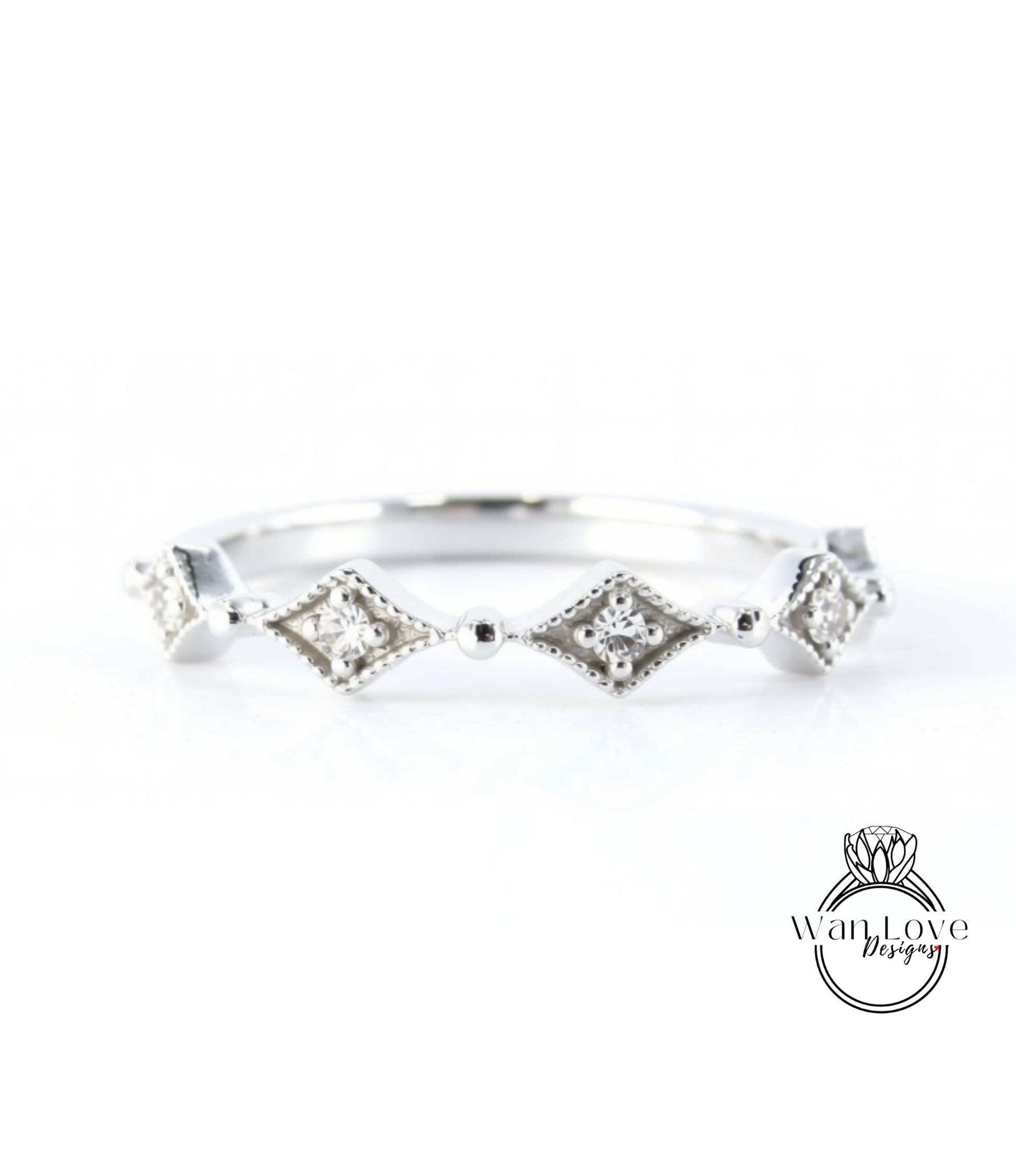 A silver ring with a row of diamond-shaped stones set in a decorative pattern.