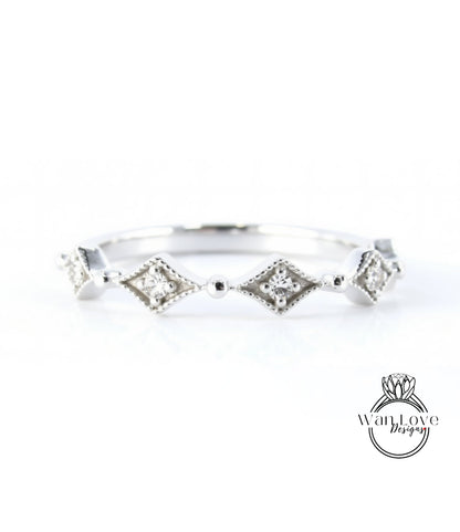 A silver ring with a row of diamond-shaped stones set in a decorative pattern.