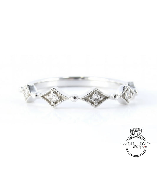 A silver ring with a row of diamond-shaped stones set in a decorative pattern.