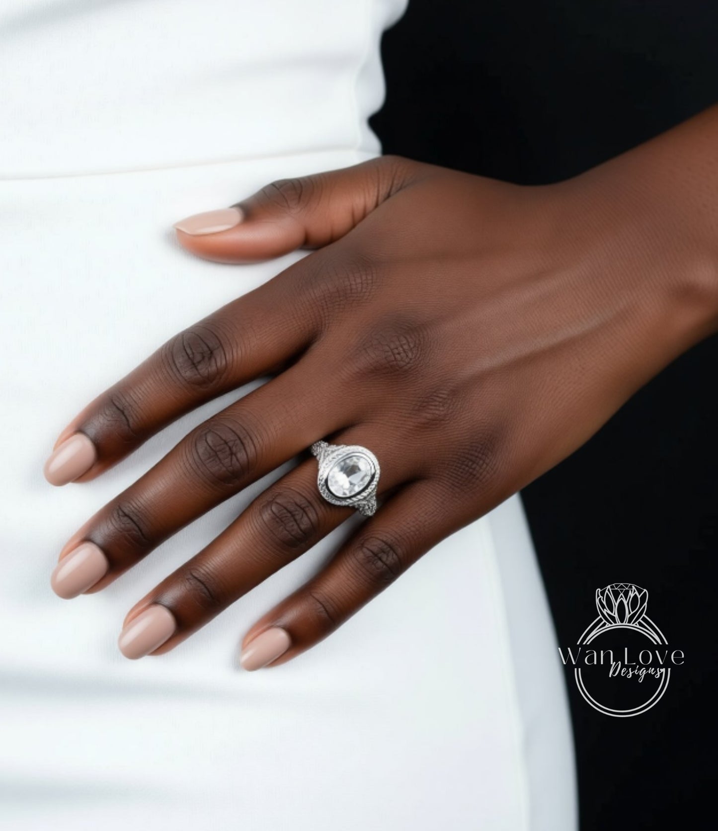 A close-up of a hand wearing a large, ornate ring on the ring finger.