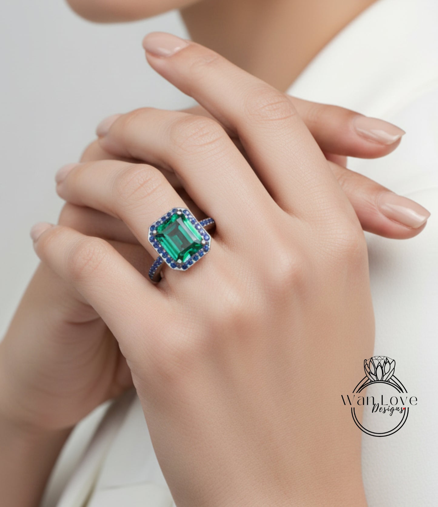 A close-up of a person's hand wearing a large, ornate ring with a large, green gemstone.