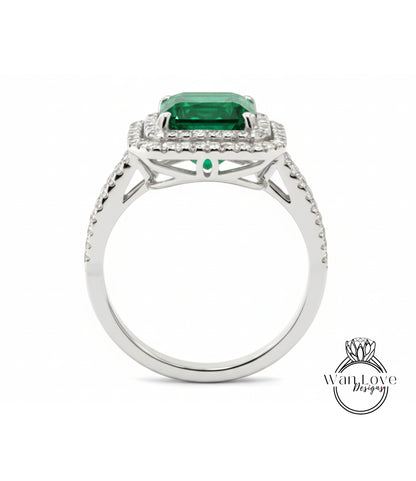 A silver ring with a large, square-cut green gemstone set in a halo of smaller diamonds.