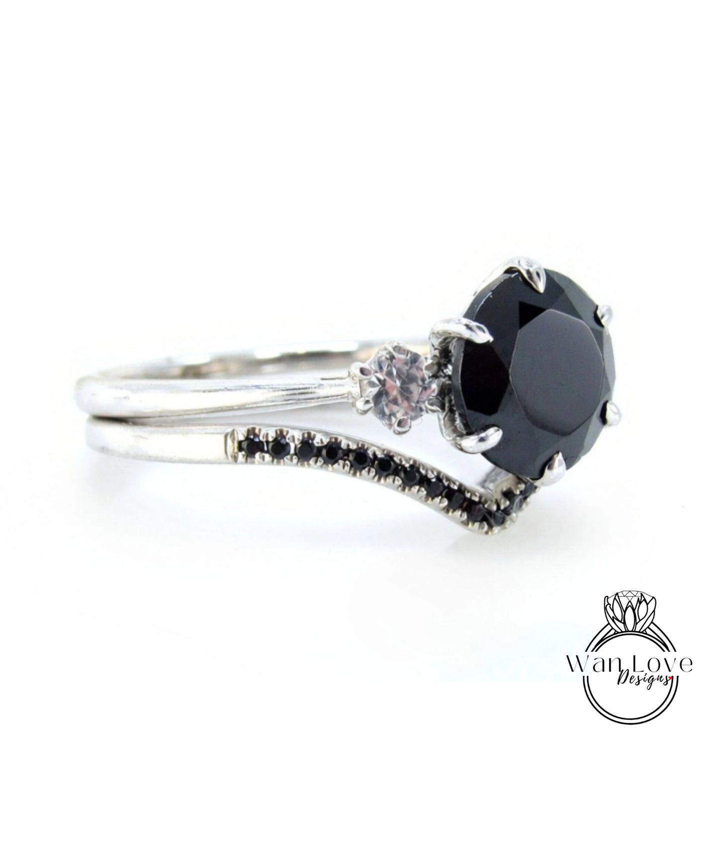 A silver ring with a large black gemstone, possibly a diamond, and a smaller gemstone. The ring has a curved band and small black stones on the sides.