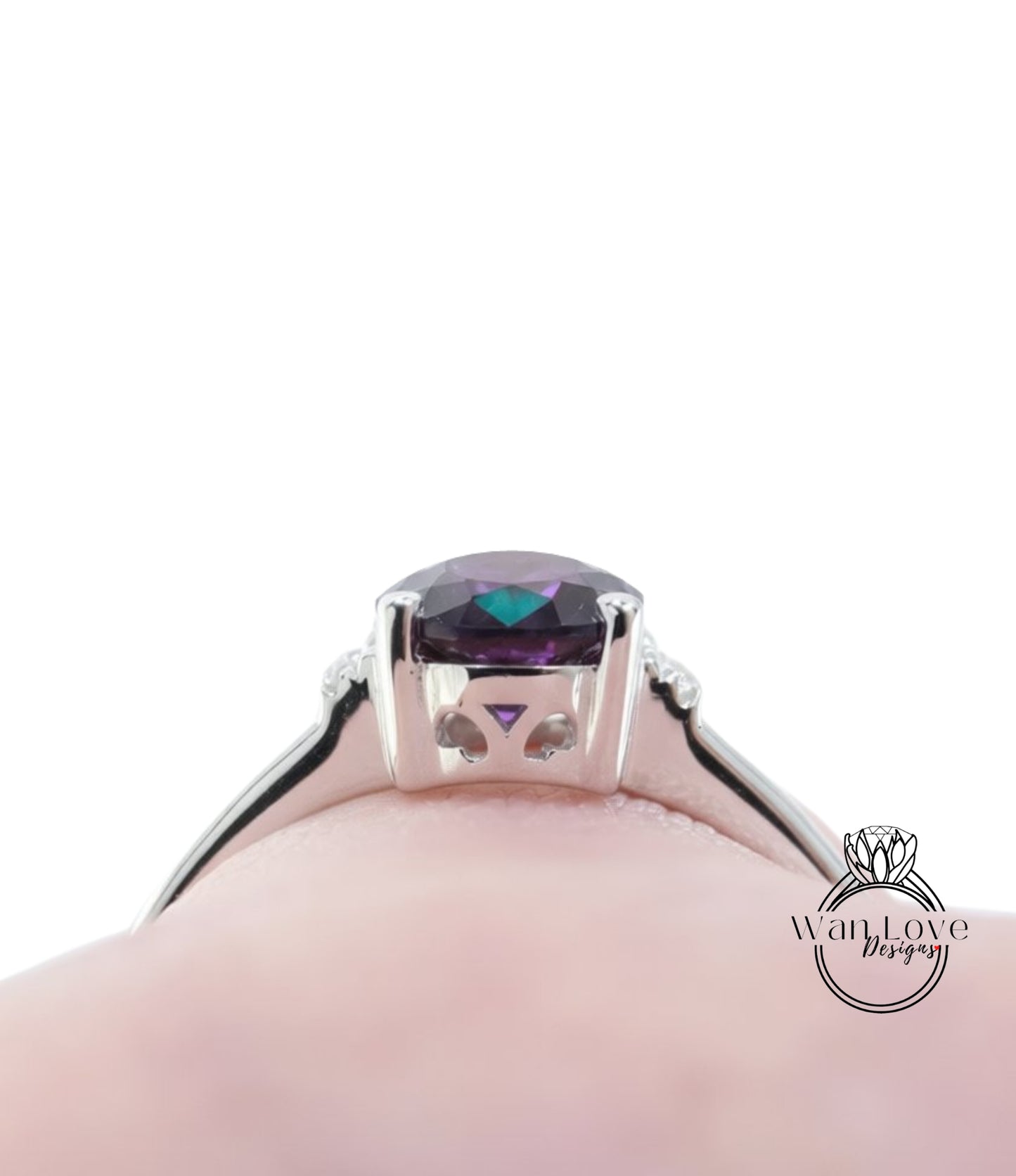 A close-up view of a silver ring with a large purple gemstone, likely an amethyst, set in the center.