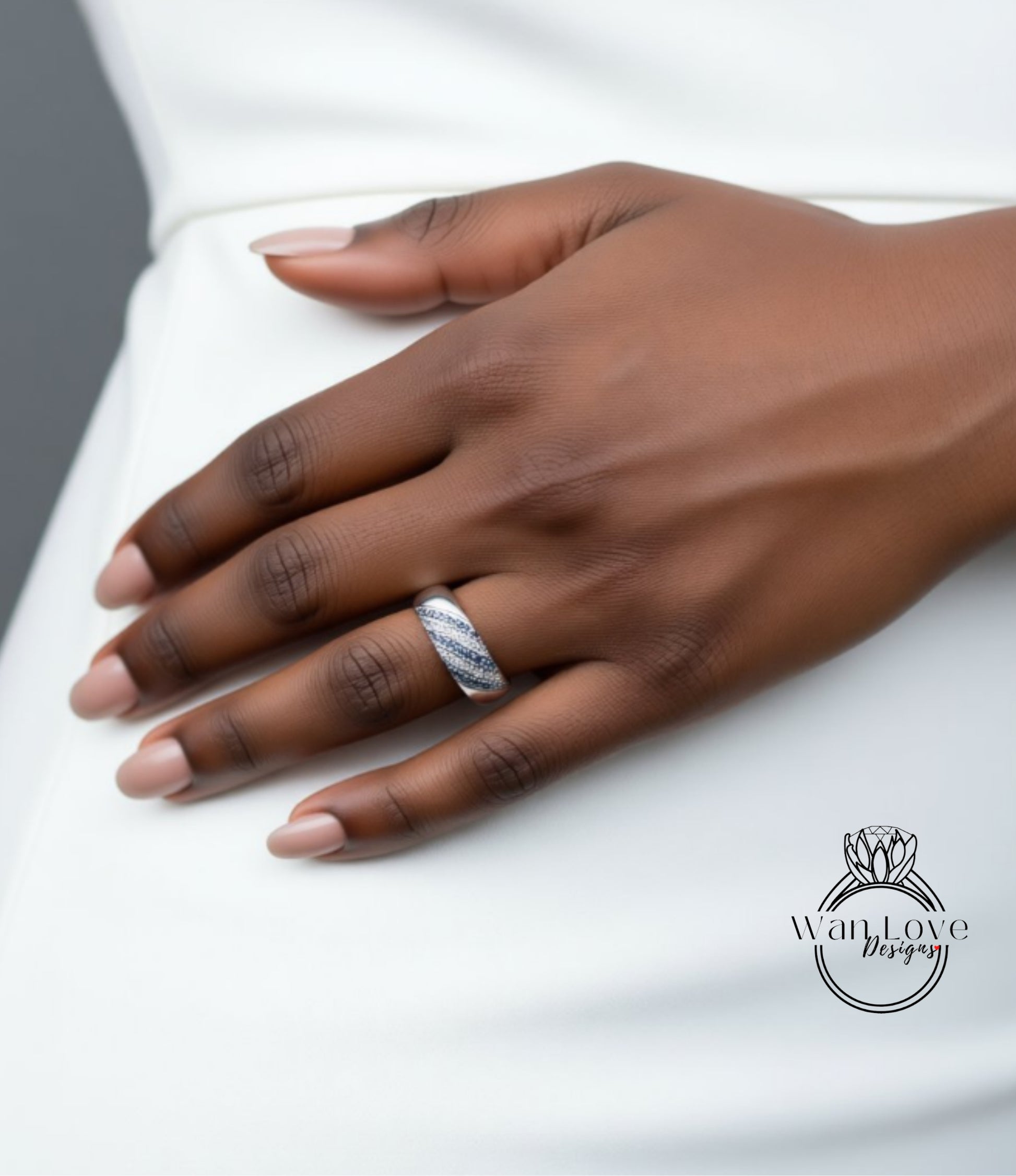 A close-up of a hand wearing a ring on the ring finger.