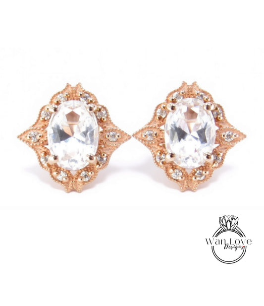 A pair of elegant gold earrings with large, clear gemstones set in an ornate, decorative design.