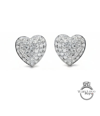 A pair of elegant diamond-encrusted heart-shaped earrings against a white background.