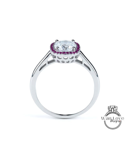 A silver ring with a large central gemstone surrounded by smaller purple stones.