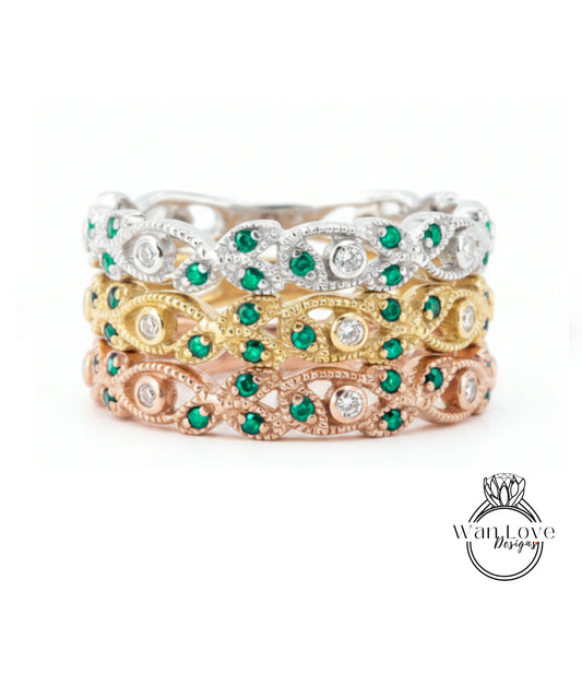 A stack of three rings with green gemstones and diamonds set in various colored metals, including silver, gold, and rose gold.