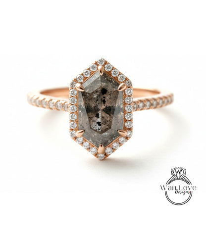 A rose gold ring with a large, irregularly shaped diamond set in the center, surrounded by smaller diamonds.