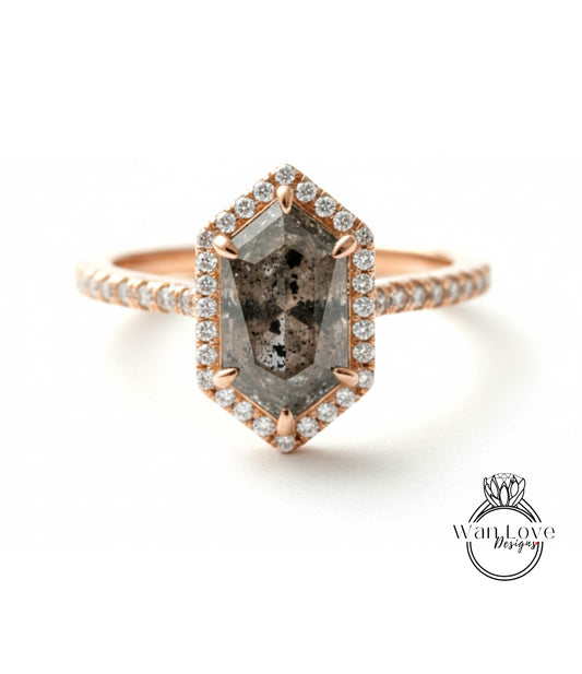 A rose gold ring with a large, irregularly shaped diamond set in the center, surrounded by smaller diamonds.