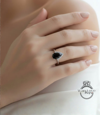 A close-up of a person's hand wearing a ring with a large black gemstone.