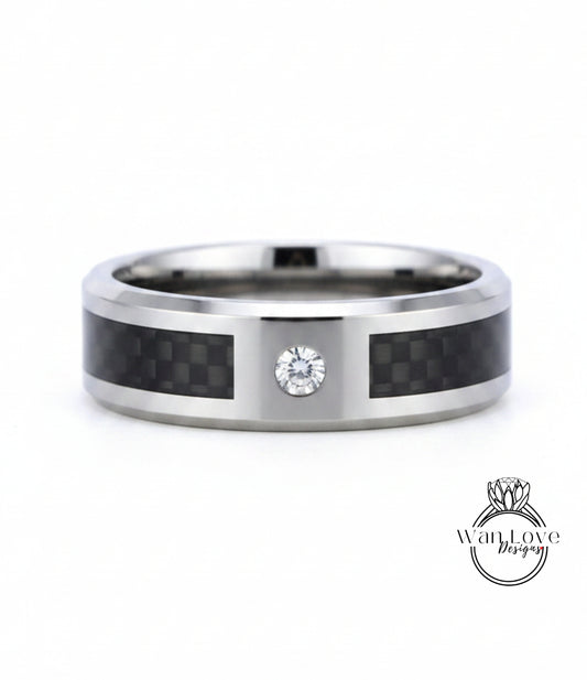 A silver ring with a carbon fiber band and a diamond set in the center.