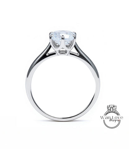 A silver engagement ring with a large, clear gemstone set in the center of the band.